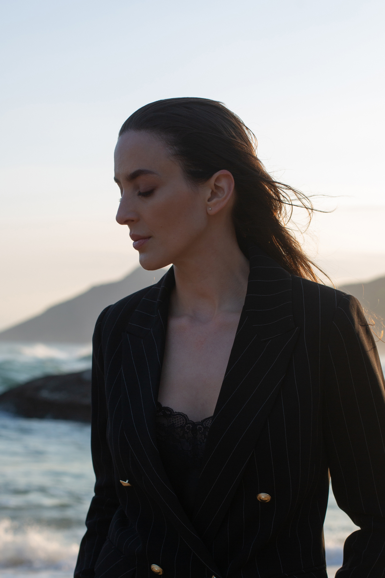 Anna David em retrato na praia ao entardecer